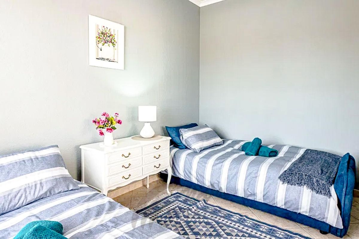 A bedroom featuring tiled flooring and neutral wall finishes, providing a functional space for sleeping arrangements.