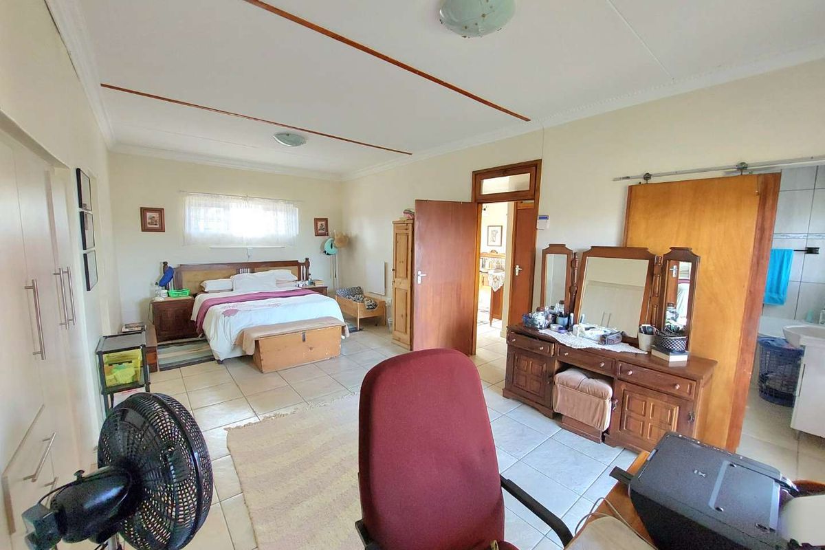 Spacious bedroom featuring tiled flooring, built-in cupboards, and an en-suite bathroom access point.