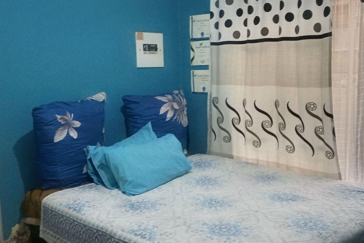 A bedroom featuring blue painted walls and a built-in electrical distribution board.