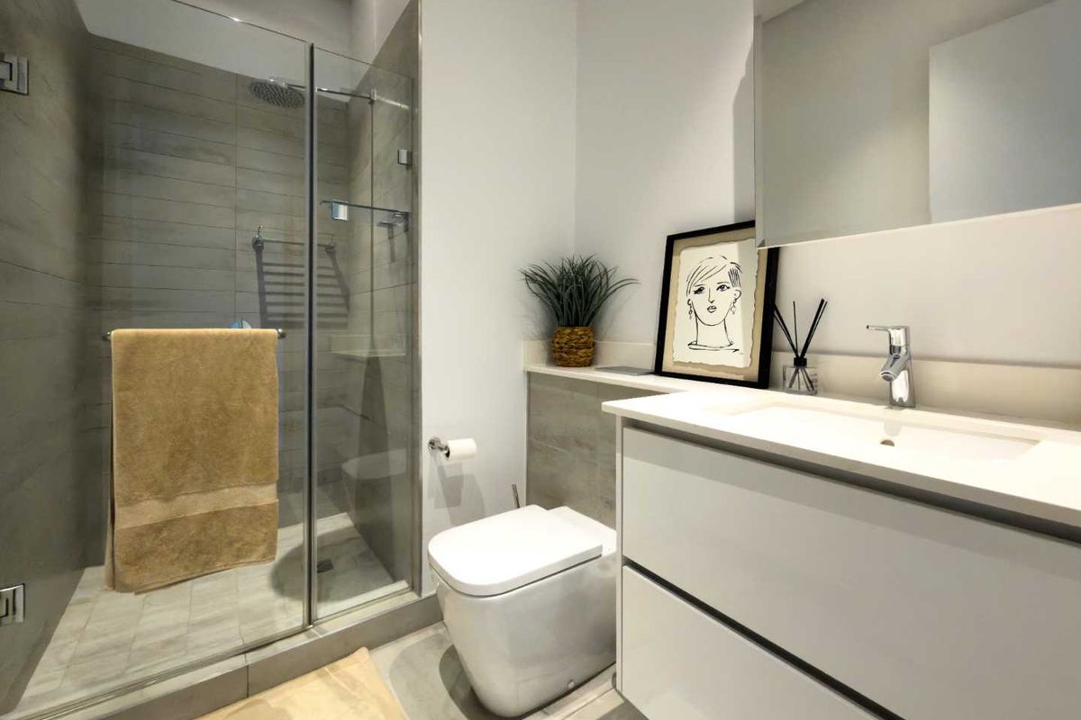 Modern bathroom featuring a glass-enclosed walk-in shower with grey tiling, a wall-mounted toilet, and a sleek white vanity with an integrated basin.
