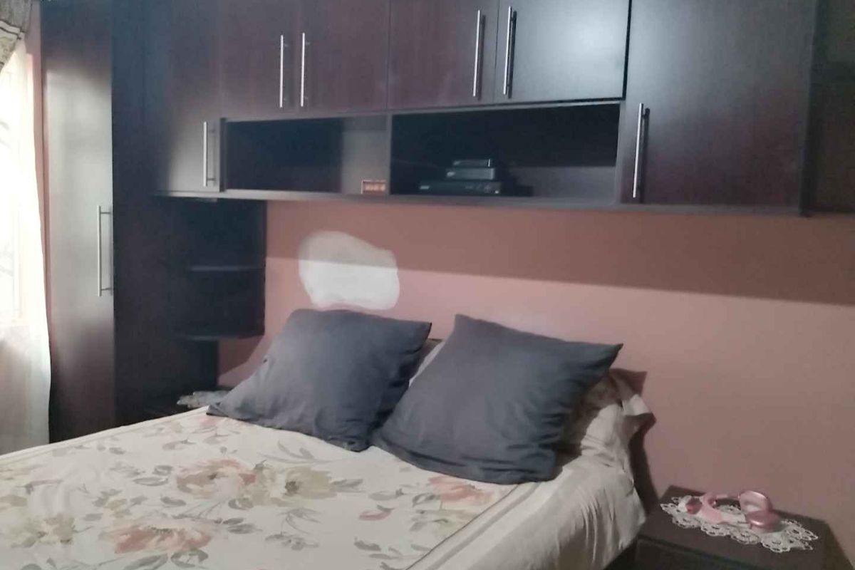 Bedroom featuring built-in dark wood cabinetry and overhead storage units.
