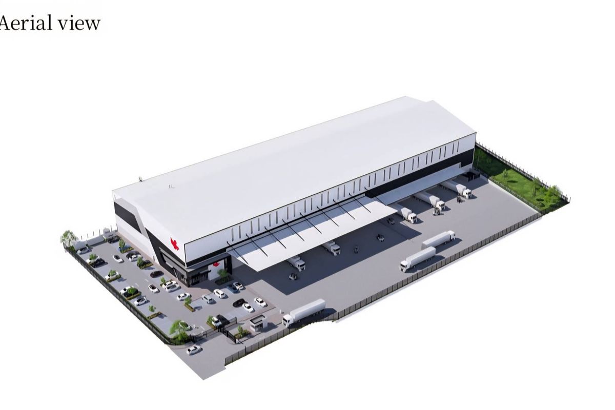 Aerial view of a modern industrial warehouse facility featuring a large loading bay, extensive paved yard, and secure perimeter fencing.