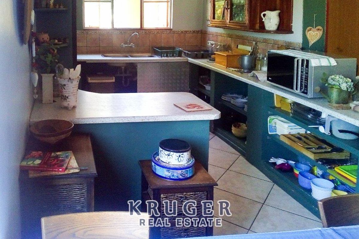 A functional kitchen featuring built-in cabinetry, a double basin sink, and tiled flooring, offering a practical layout for daily meal preparation.