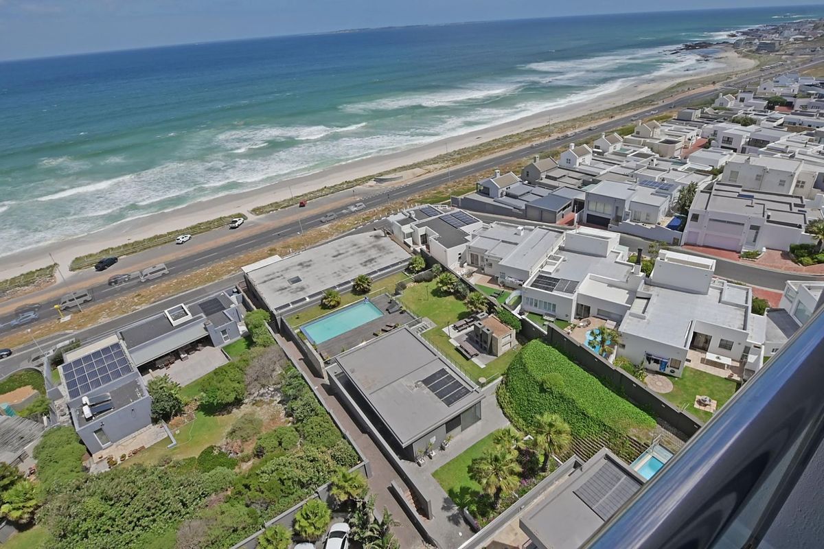 An elevated aerial view overlooking a coastal residential neighborhood with direct beach access and ocean views.