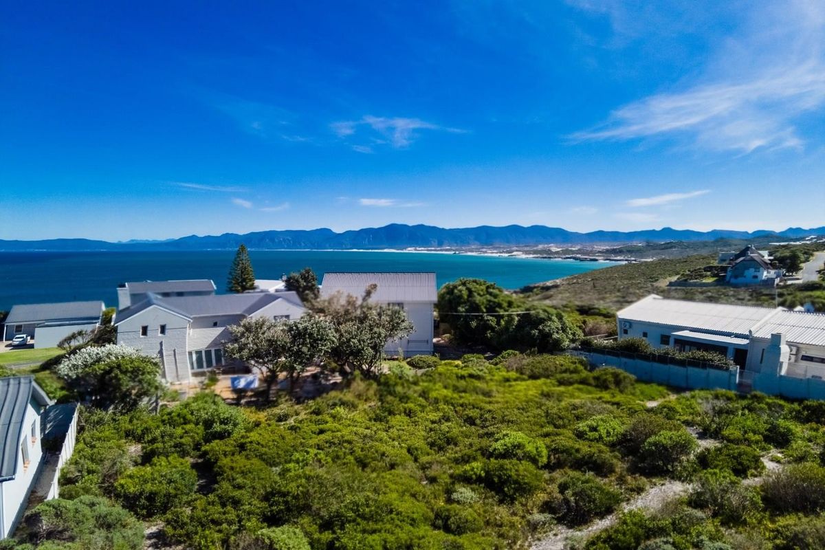 Aerial view of the coastal property showcasing the surrounding landscape, proximity to the ocean, and mountain vistas.