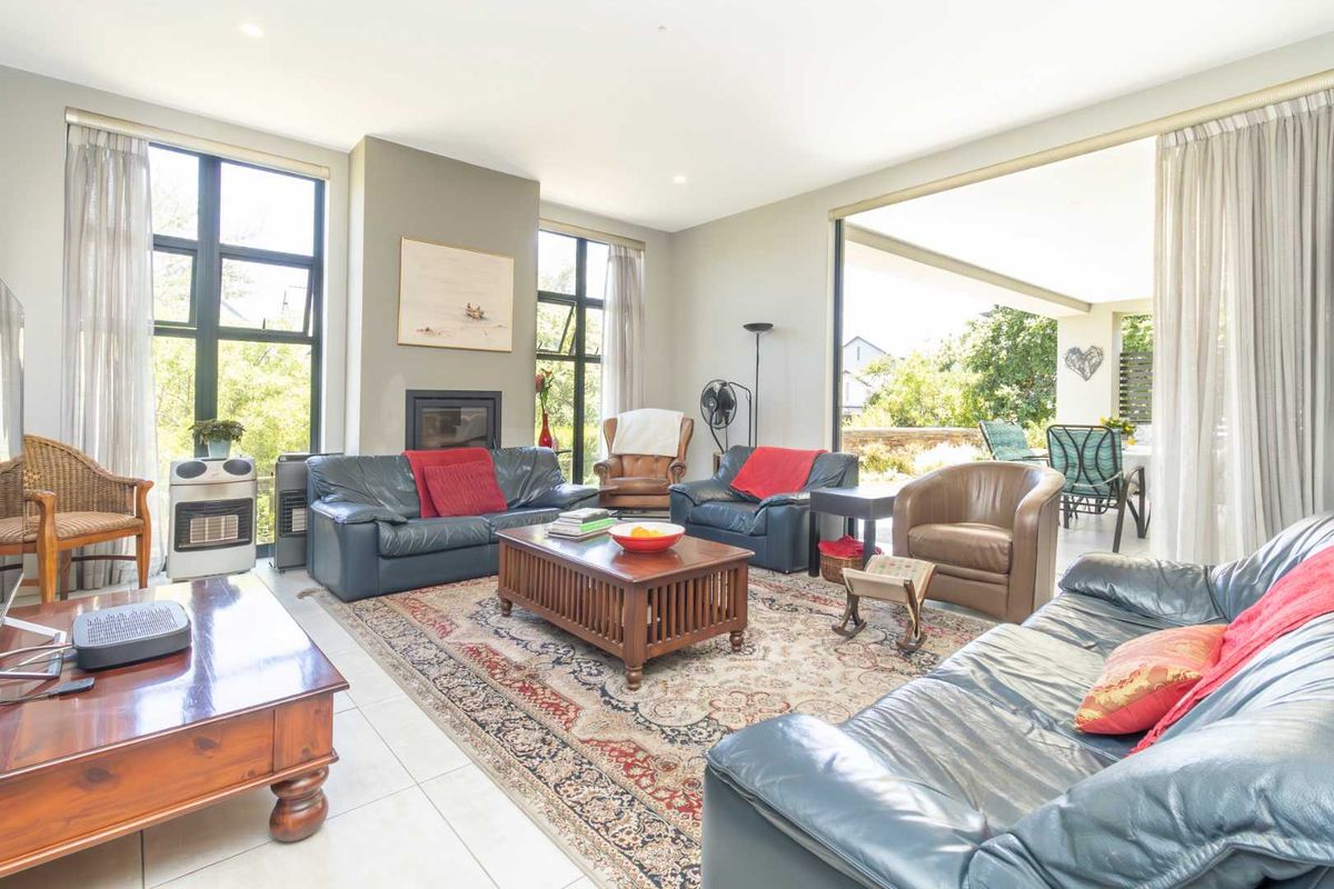 Spacious living room featuring a built-in fireplace, large windows, and seamless flow to an outdoor patio area.