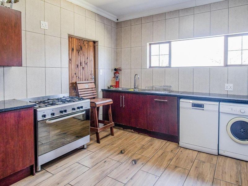 A functional kitchen featuring dark wood cabinetry, granite countertops, gas stove, and tiled finishes, providing a practical workspace for daily meal preparation.