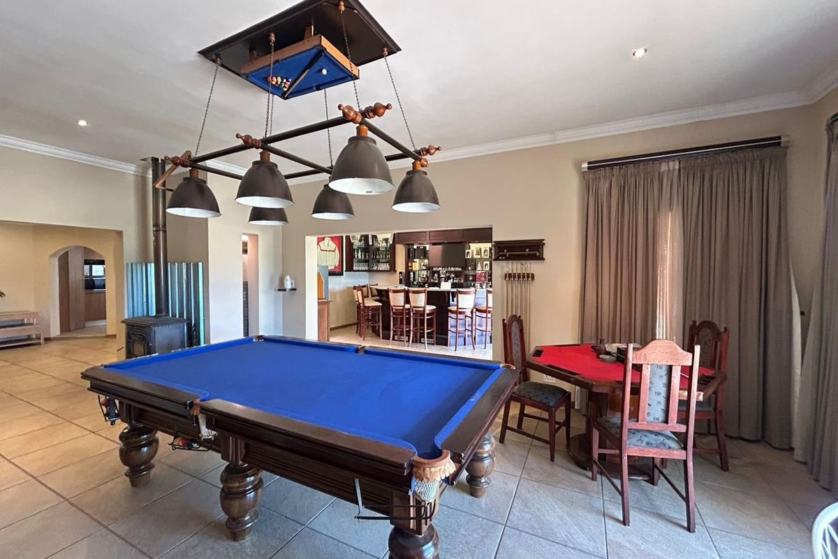 Spacious entertainment area featuring a built-in bar, wood-burning fireplace, and tiled flooring, ideal for hosting guests in a relaxed farm-style setting.