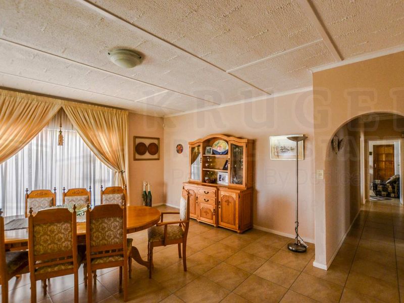 Dining room featuring tiled flooring, an arched entryway leading to the hallway, and a textured ceiling.