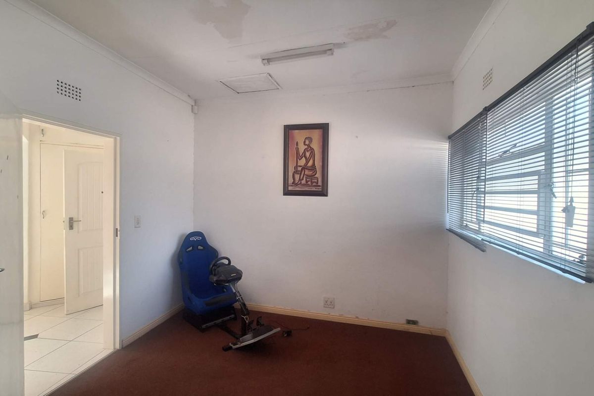 A bedroom featuring carpeted flooring, venetian blinds, and visible ceiling water staining, offering a blank canvas for renovation or restyling.