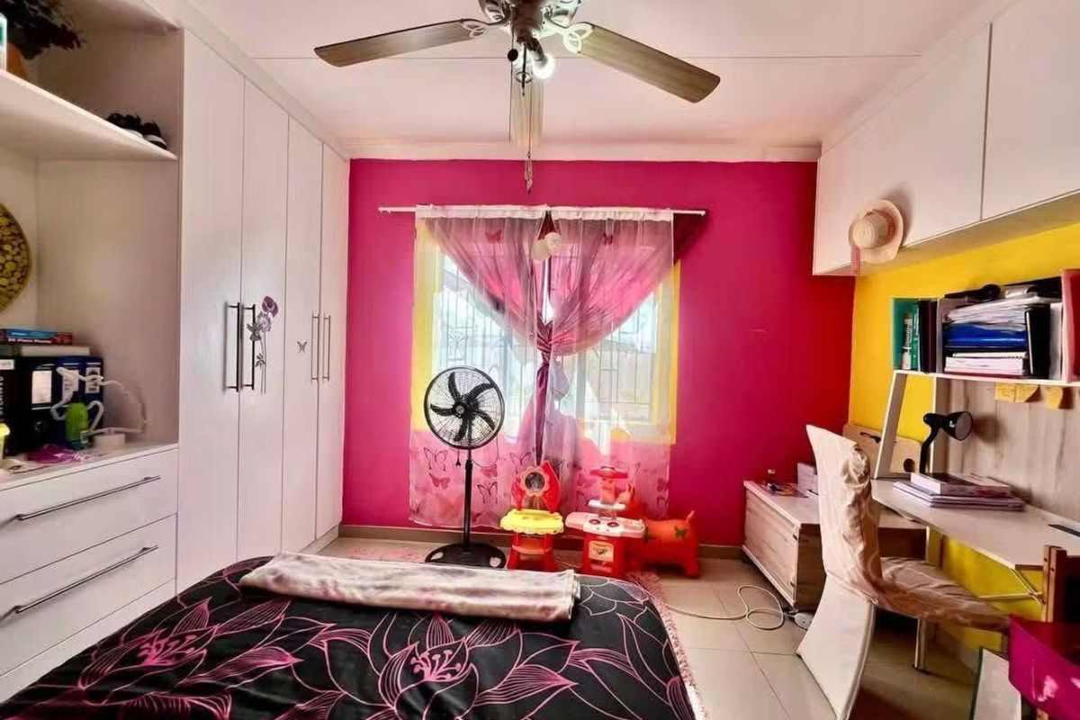 A bedroom featuring built-in cupboards, overhead storage cabinets, a ceiling fan, and tiled flooring, offering practical storage and functional living space.
