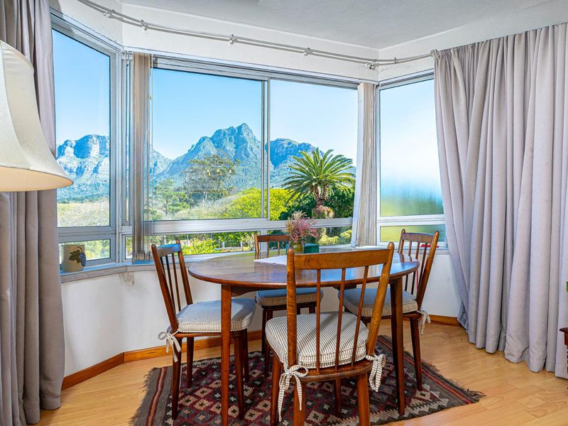 A bright dining area featuring large bay windows with scenic mountain views and laminate flooring.