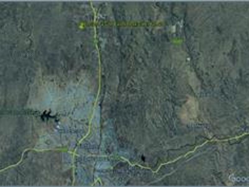 An aerial satellite view showing the surrounding landscape and regional terrain of the vacant land property.