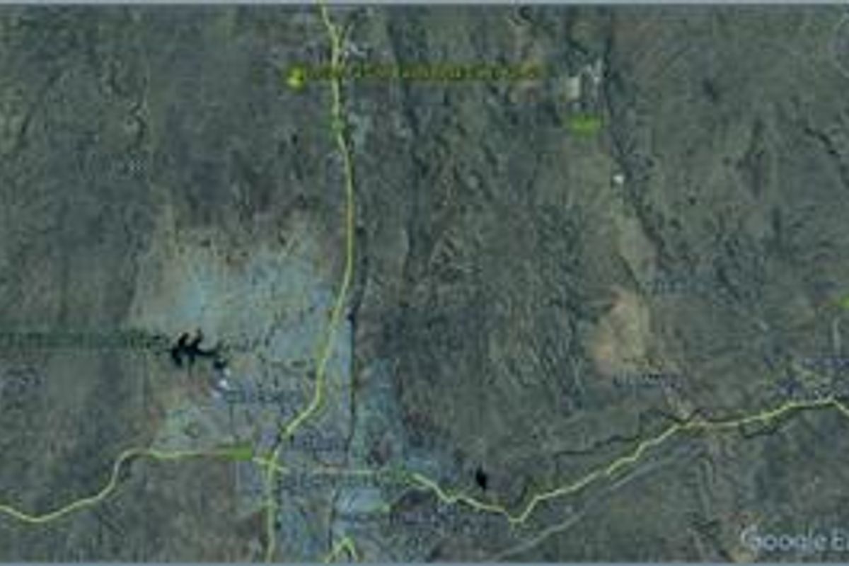 An aerial satellite view showing the surrounding landscape and regional terrain of the vacant land property.