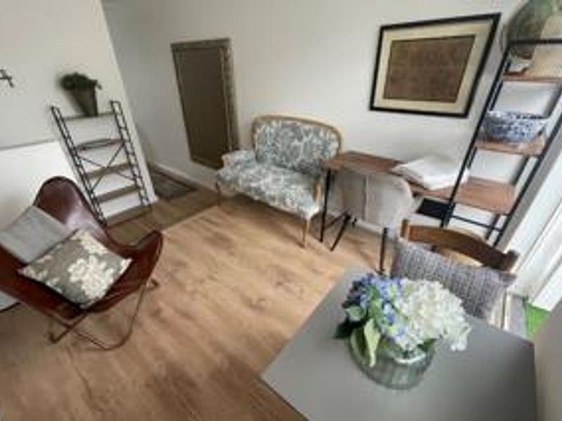 A cozy living area featuring light wood-look laminate flooring and a sliding glass door providing natural light.
