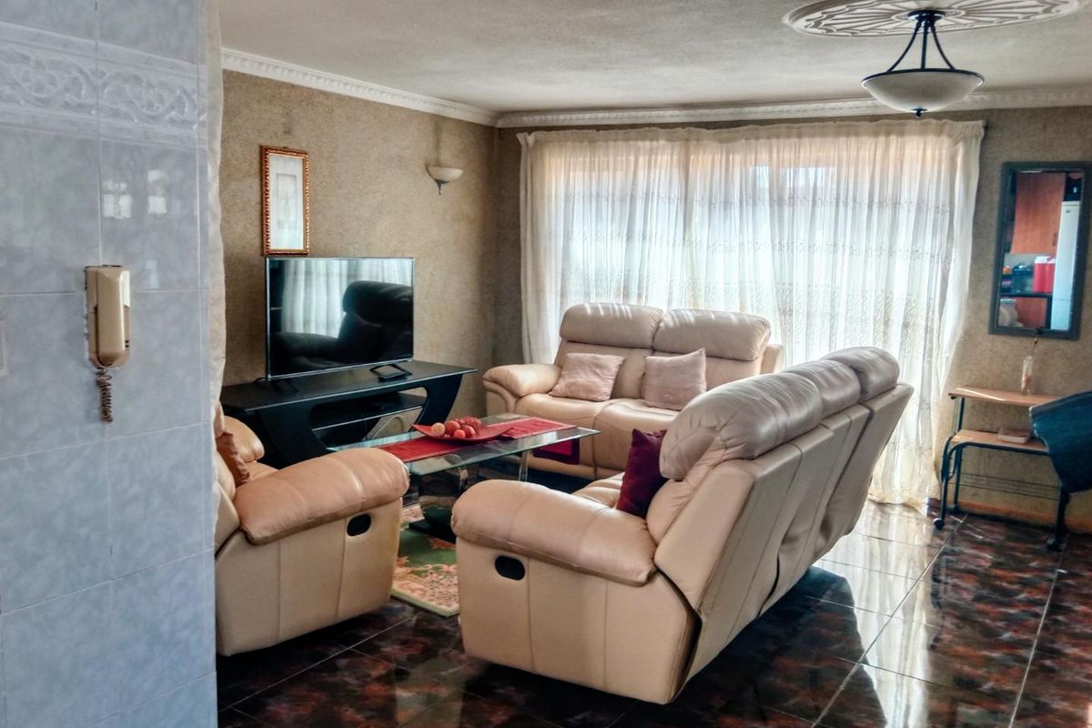 A living room featuring tiled flooring, decorative ceiling rose, and coving, providing a functional space with an integrated intercom system.