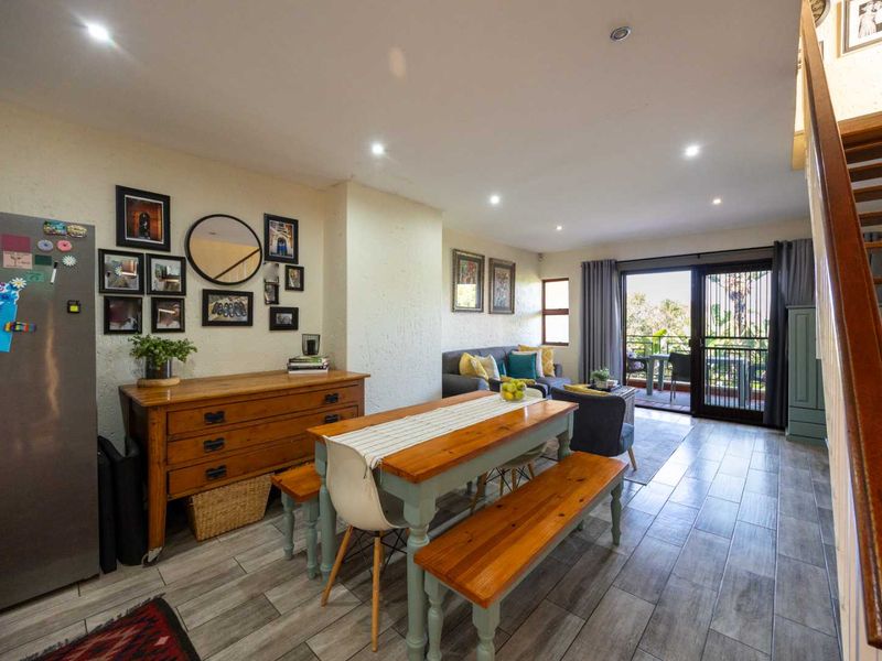 Open-plan living and dining area featuring tiled floors, recessed lighting, and direct access to an outdoor patio through sliding glass doors.