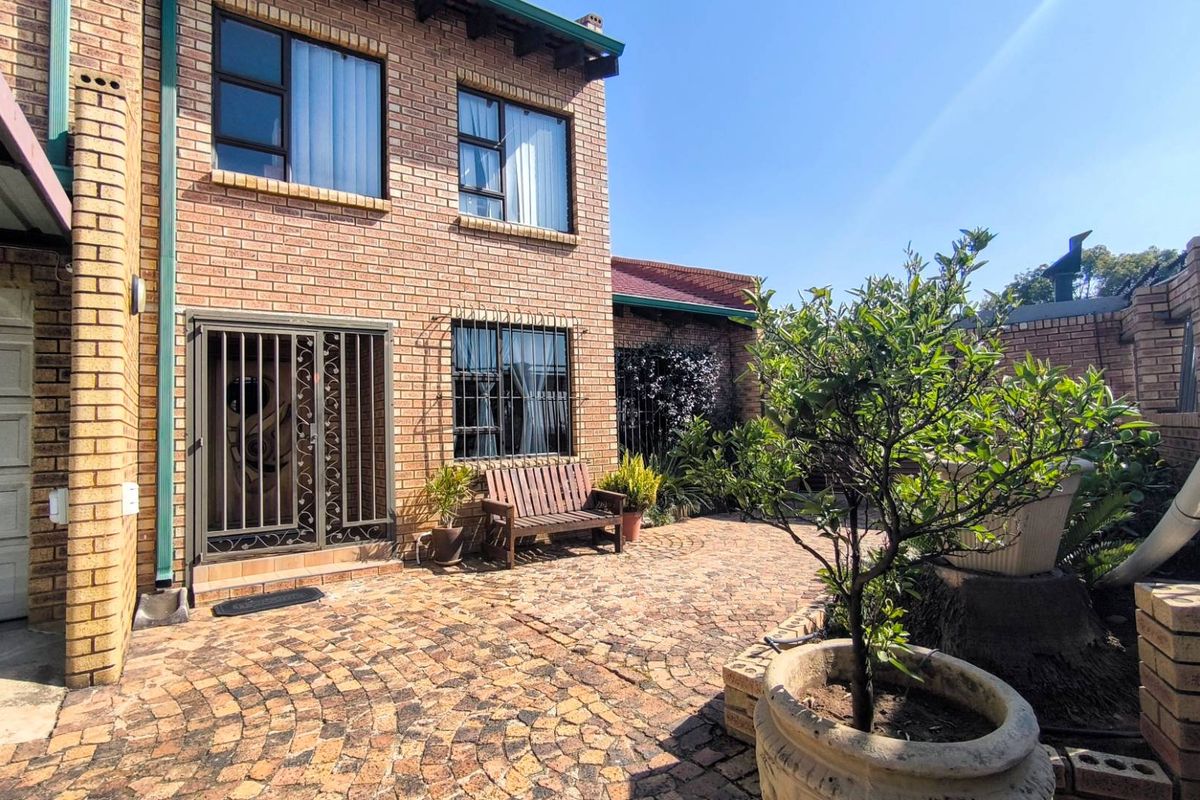 A private rear courtyard featuring brick paving, a brick facade, and secure access points, providing a low-maintenance outdoor living space.