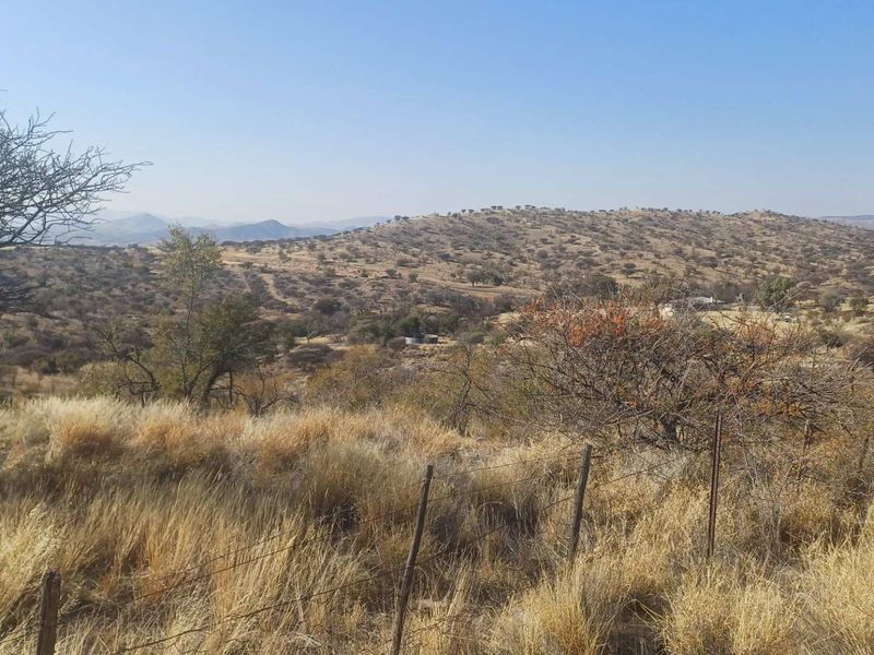 Expansive landscape view overlooking the surrounding farm terrain with natural vegetation and rolling hills.
