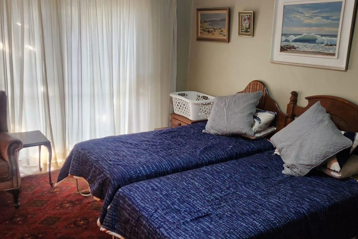 A bedroom featuring a sliding glass door with curtains, providing natural light and access to the exterior.