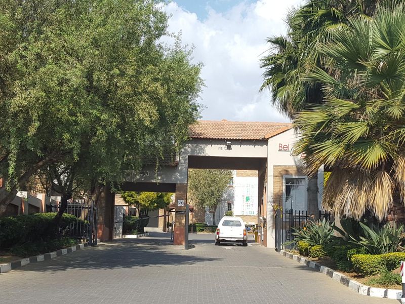 The entrance to the apartment complex features a secure gatehouse, paved driveway, and established landscaping, providing a welcoming and well-maintained arrival point.