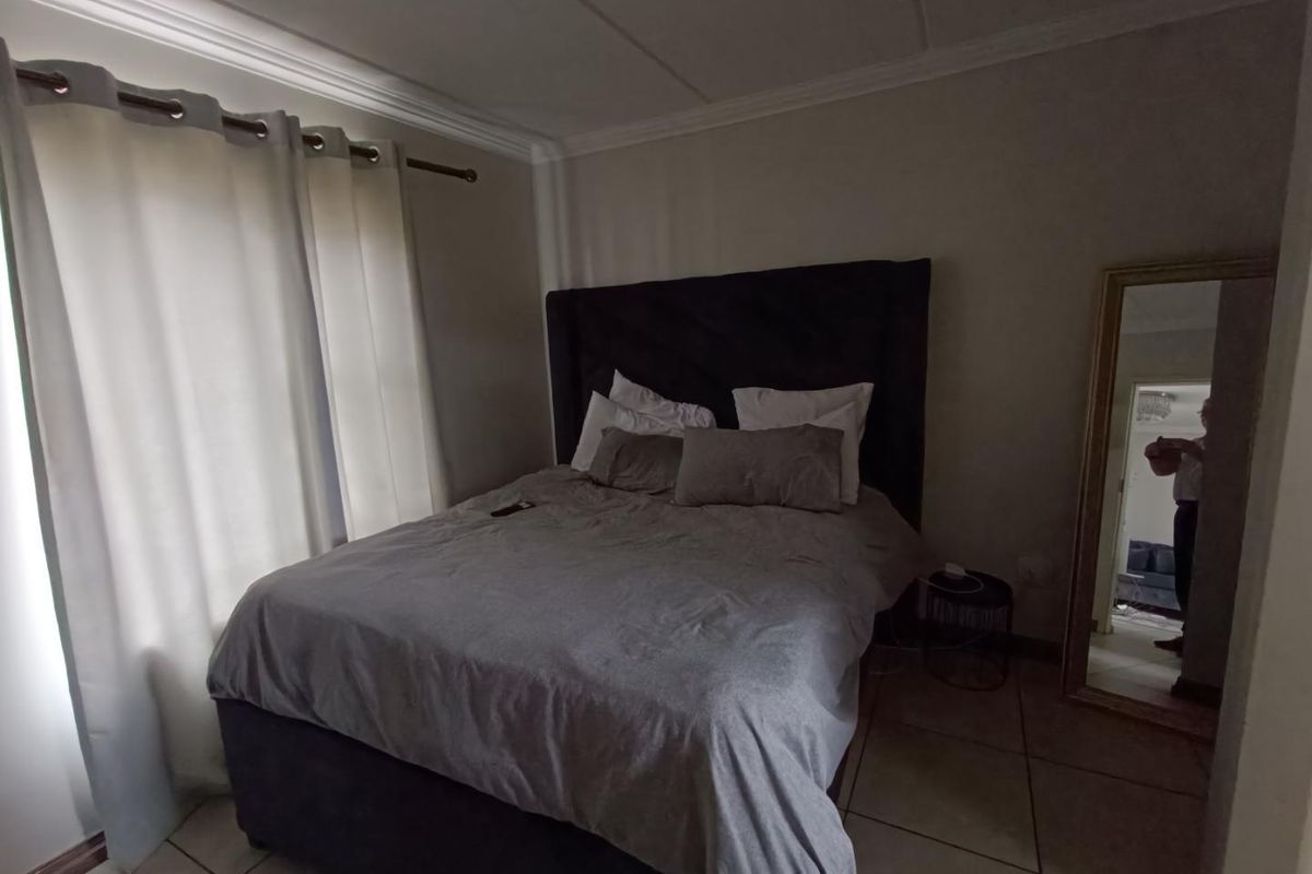 A bedroom featuring tiled flooring, crown molding, and a window with curtain tracks.