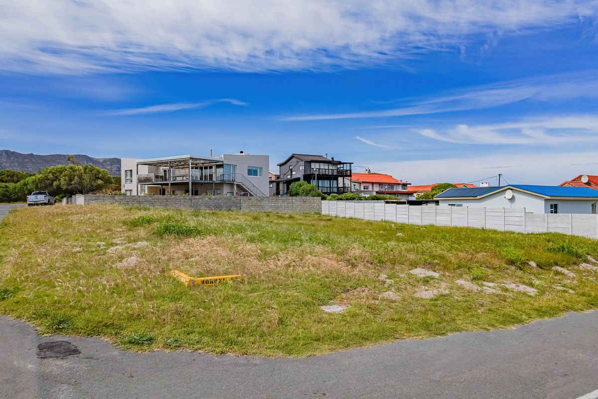 A vacant residential plot situated on a corner lot, featuring street access and established boundary walls in a developed neighborhood.