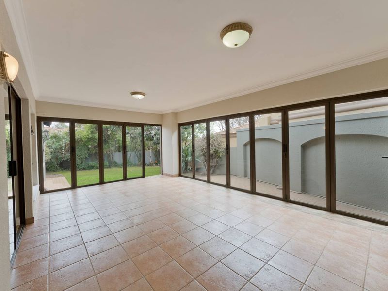 Spacious enclosed patio featuring large aluminium stacker doors that provide seamless access to the garden and outdoor area.