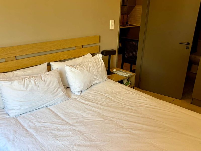A bedroom featuring built-in cupboards and an internal door leading to an adjacent space.