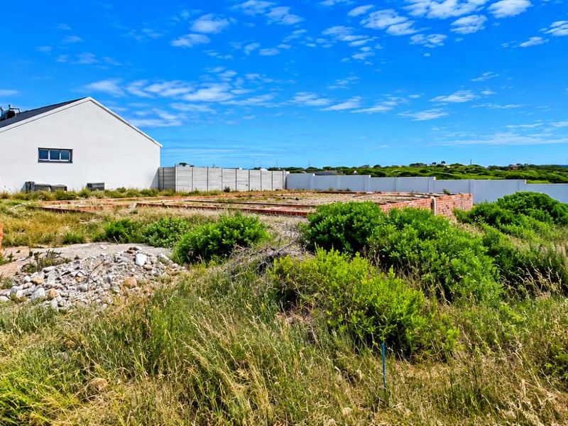 Vacant residential land featuring a brick foundation slab, enclosed by precast concrete boundary walls, situated adjacent to an existing residential property.