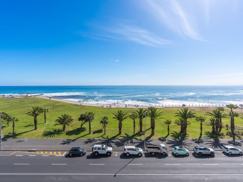 A scenic elevated view overlooking the coastal promenade, public parkland, and the ocean horizon.