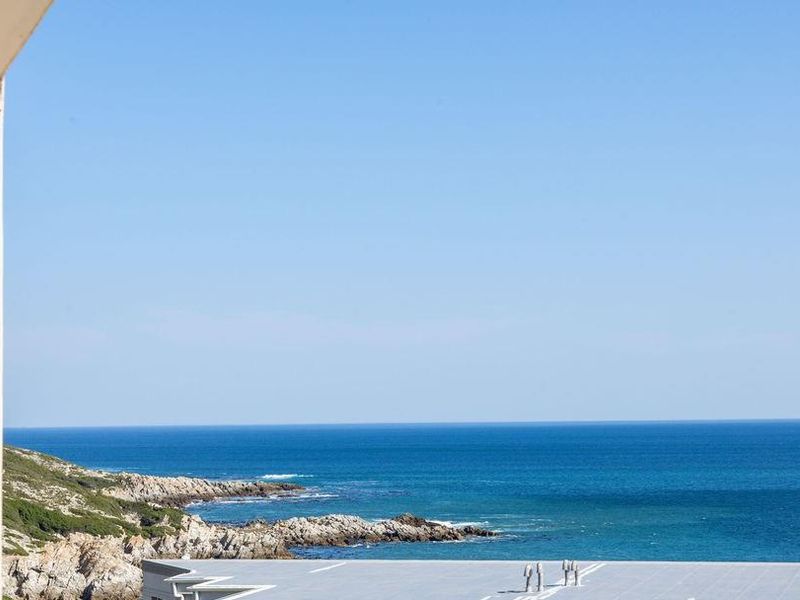 A clear, elevated view of the coastline and ocean, captured from an apartment balcony.