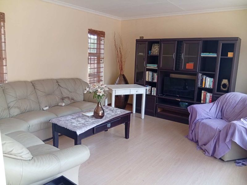 A comfortable living room featuring light-toned laminate flooring and neutral wall finishes, providing a versatile space for relaxation.