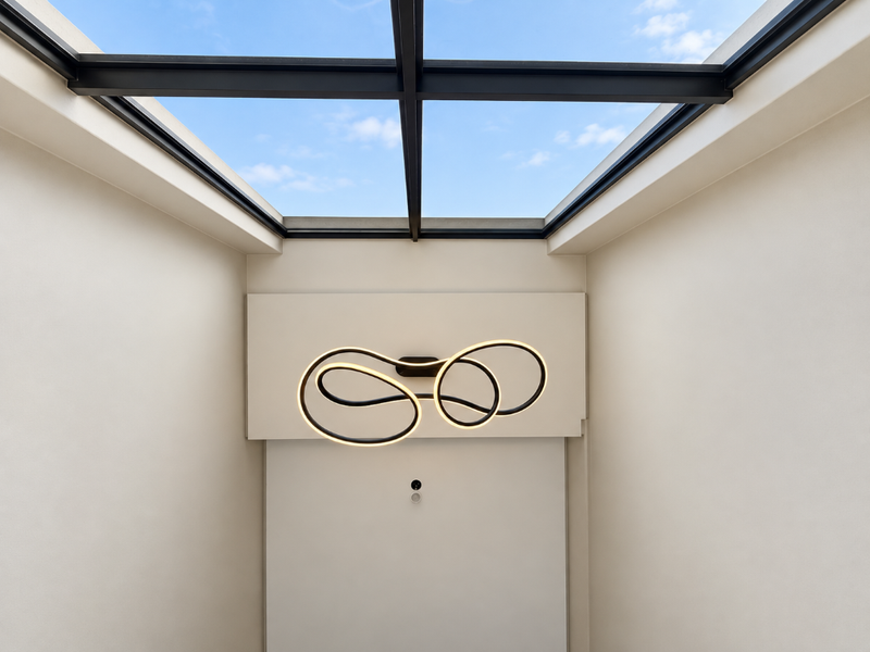 A bright, modern hallway featuring a large overhead skylight and a contemporary sculptural light fixture.
