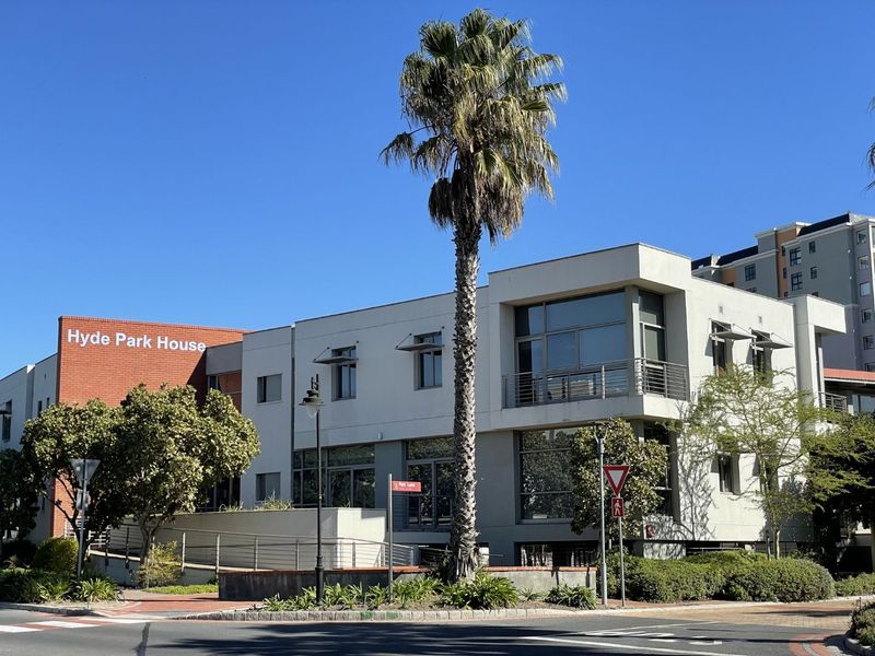 Front exterior view of Hyde Park House, a modern office building featuring a mix of brick and rendered finishes, large windows, and landscaped surroundings.