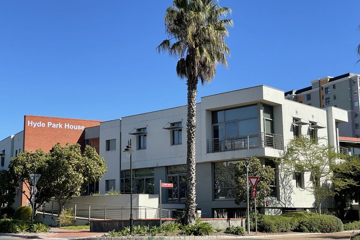 Front exterior view of Hyde Park House, a modern office building featuring a mix of brick and rendered finishes, large windows, and landscaped surroundings.