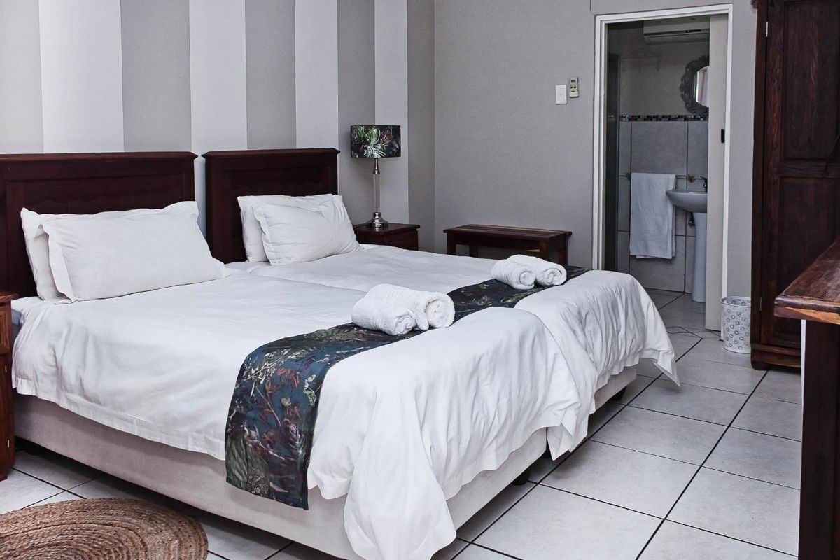 A bedroom featuring tiled flooring and an en-suite bathroom, providing a functional and comfortable living space.