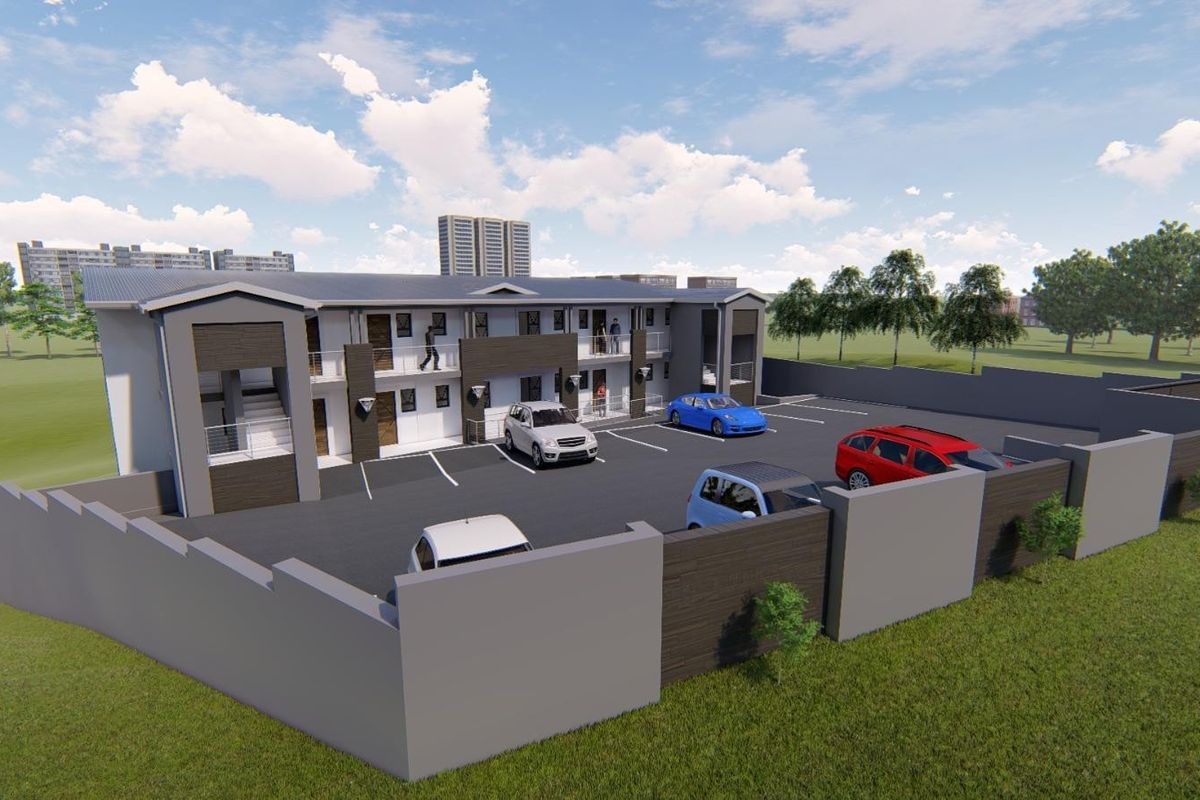 An aerial perspective of a modern townhouse complex featuring a paved parking area, perimeter walling, and multi-level residential units.