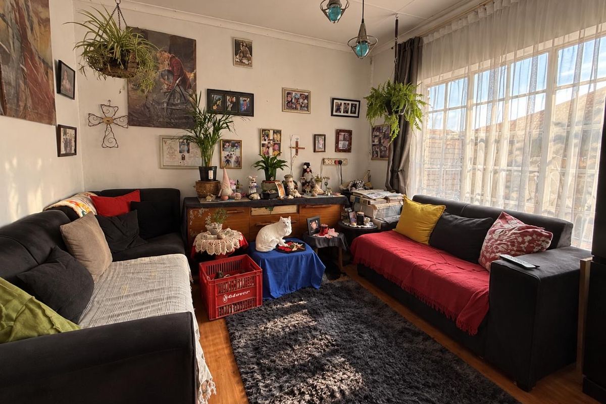 A cozy living room featuring large windows that provide ample natural light and laminate flooring throughout.