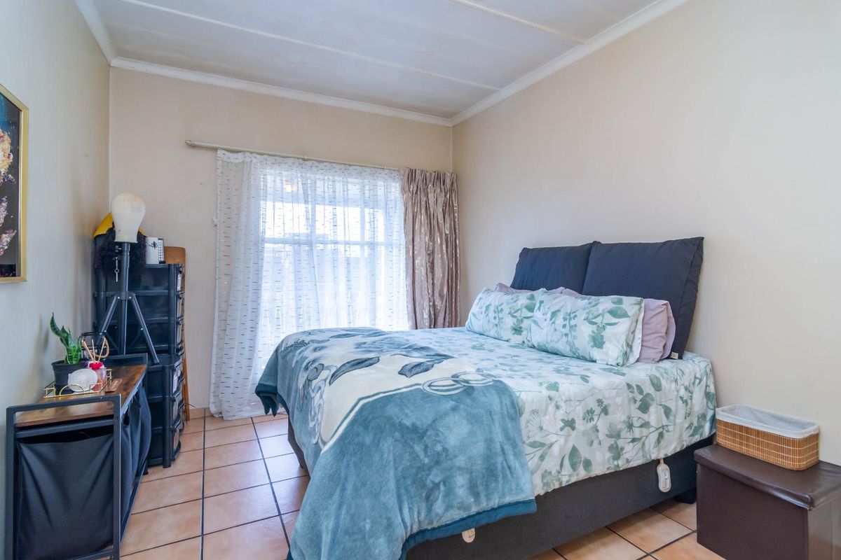 A bedroom featuring tiled flooring and a window with a curtain rail.