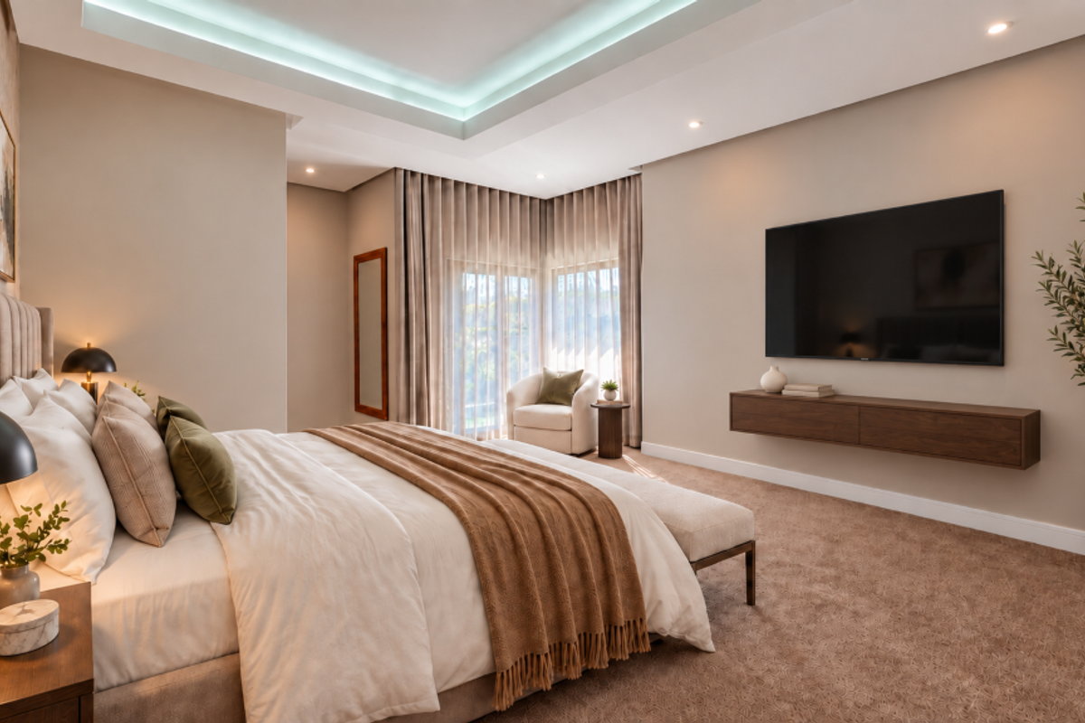 A well-appointed bedroom featuring a recessed ceiling with ambient cove lighting, plush carpeting, and a sleek wall-mounted media console.