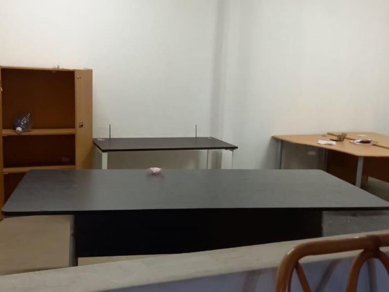 A functional office space with neutral walls, suitable for a professional work environment or small business operations.