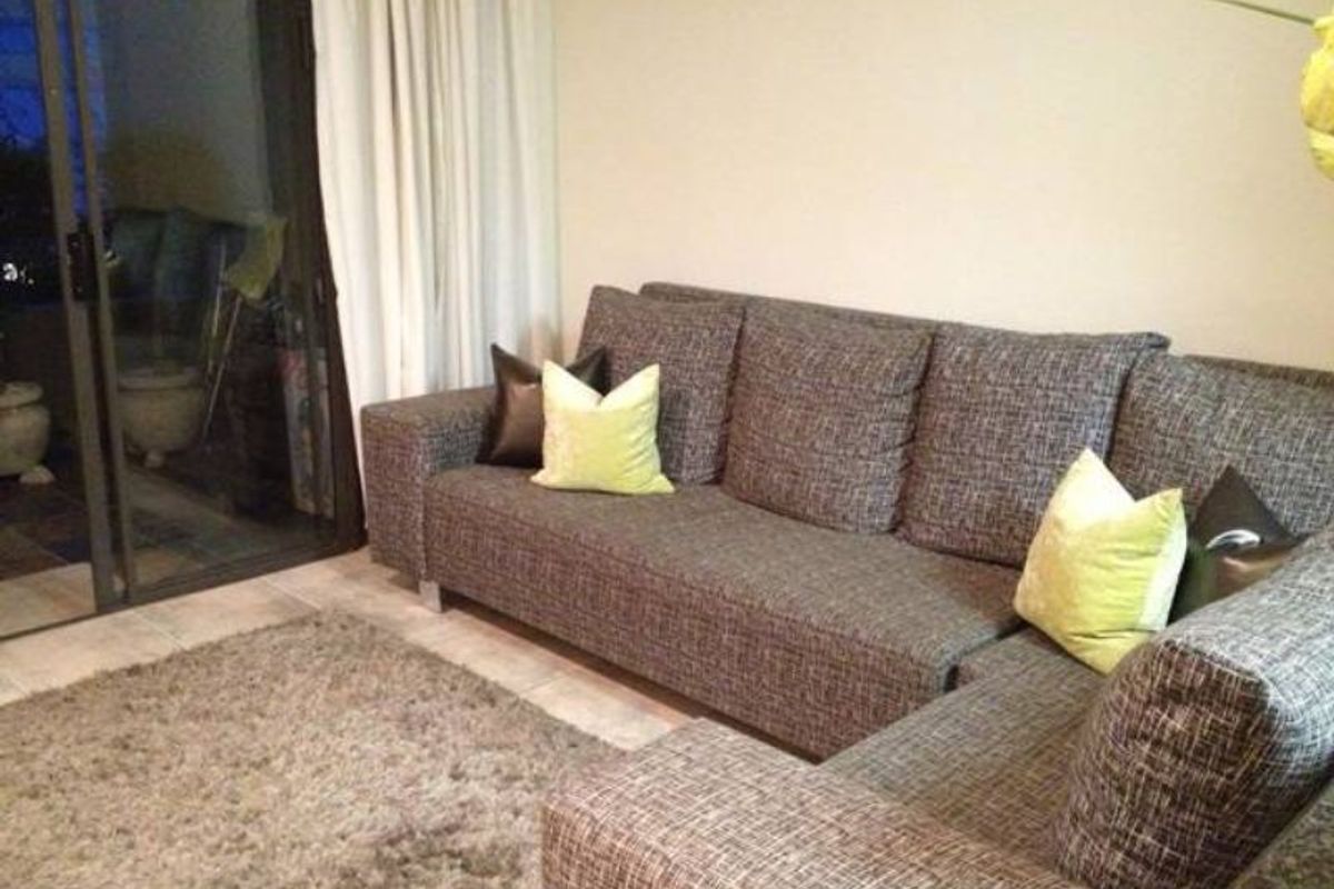 A living room area featuring a sliding glass door leading to an outdoor space, with neutral wall finishes.