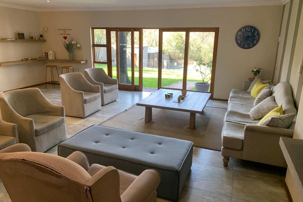 Spacious living area featuring tiled flooring, recessed lighting, and large timber-framed sliding doors providing direct access to the garden.