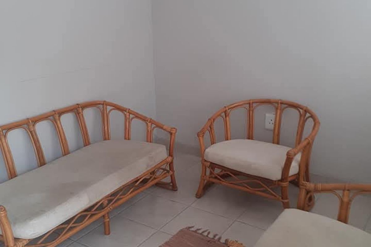 A simple living area featuring neutral tiled flooring and plain walls, providing a functional and basic space.