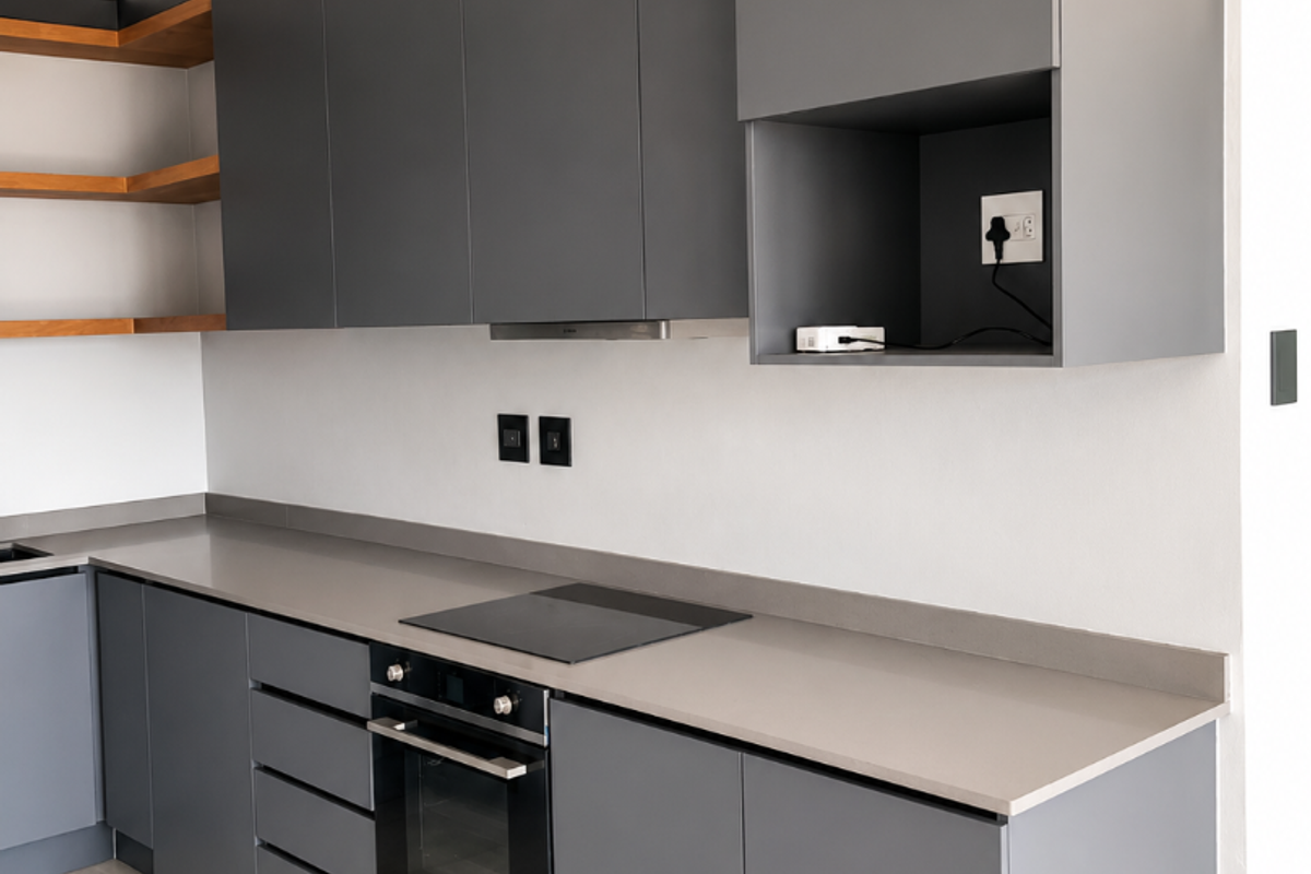 Modern kitchen featuring sleek grey cabinetry, stone countertops, built-in oven, electric hob, and open wooden shelving with neutral tiled flooring.