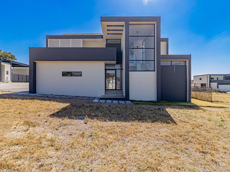 Modern architectural home featuring a striking facade with large glass windows and a clean, contemporary design.
