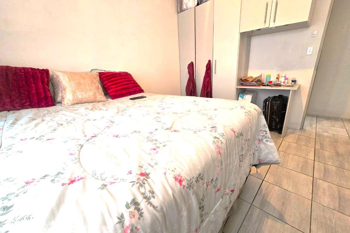 A bedroom featuring built-in cupboards and tiled flooring, providing functional storage and a neutral base for interior design.