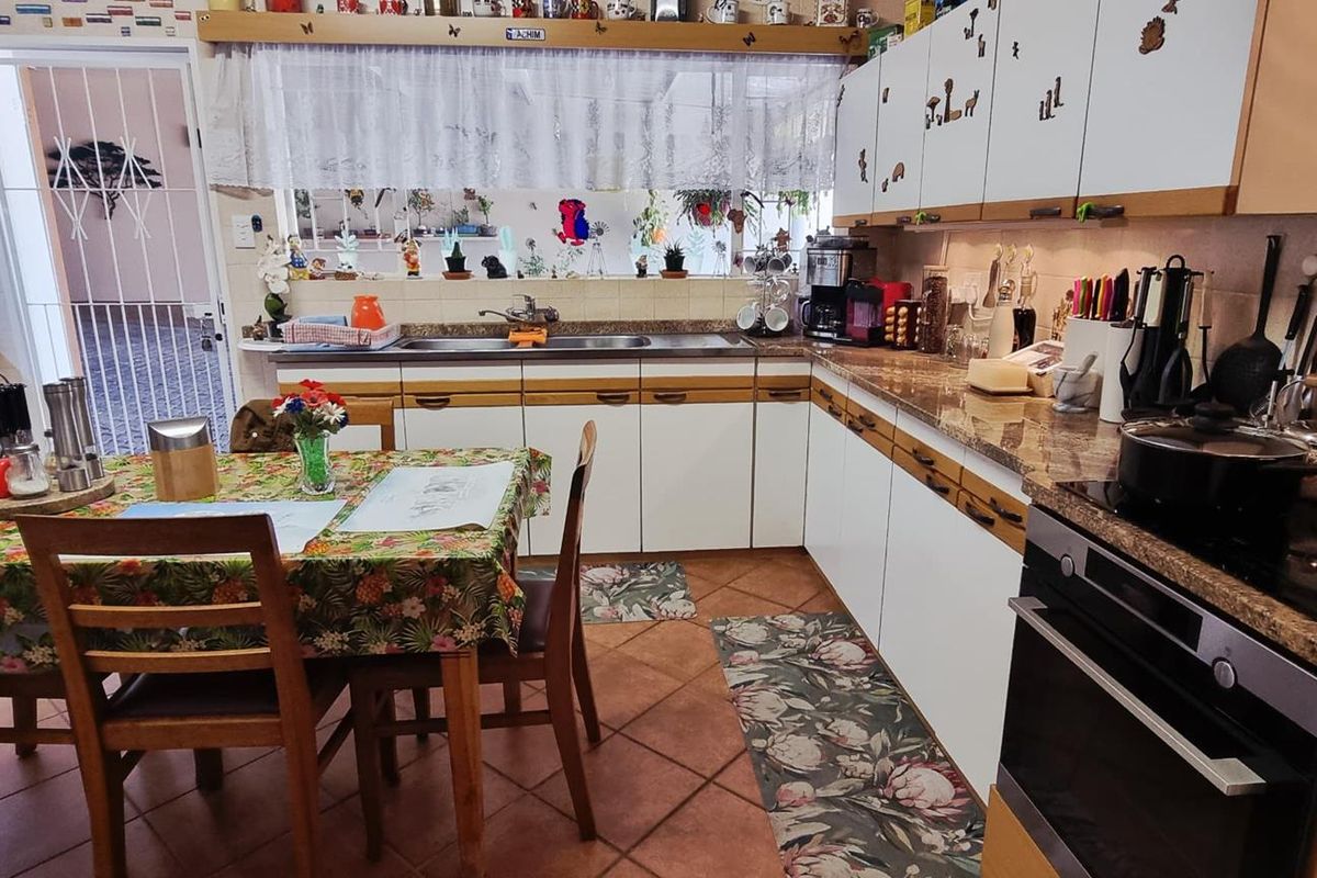 A functional kitchen featuring built-in cabinetry, granite countertops, a built-in oven, and a hob, with tiled flooring and a tiled backsplash.