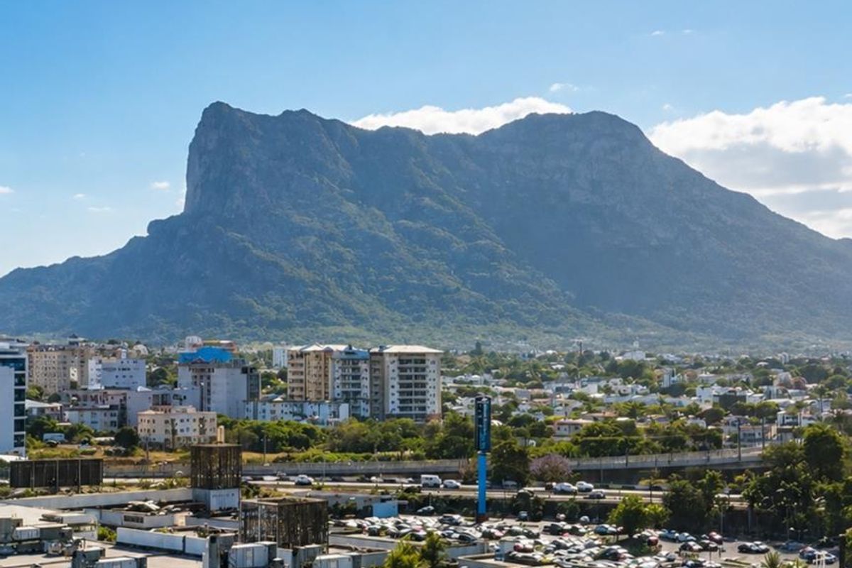 Elevated aerial view showcasing the surrounding cityscape and prominent mountain landscape.